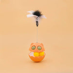Load image into Gallery viewer, Orange cat-shaped rotating feather toy with track balls and catnip for interactive pet play on tan background