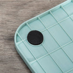 Load image into Gallery viewer, Close-up of the blue plastic base with anti-slip pad for enclosed cat litter box with lid, tray, and scoop.