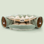 Load image into Gallery viewer, Green collapsible cat tunnel with soft cushioned interior and interactive hanging pom-pom toys for durable play and comfort