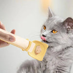 Load image into Gallery viewer, Person feeding gray cat wet food with a reusable cat strip feeder spoon dispenser close-up
