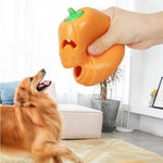 Load image into Gallery viewer, Hand holding indestructible pumpkin-shaped chew toy near attentive golden retriever dog indoors