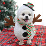 Load image into Gallery viewer, Small white dog wearing a winter Christmas snowman outfit with scarf and hat on a red plaid blanket