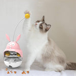 Load image into Gallery viewer, Cat playing with pink bunny-shaped tumbler leaky ball educational treat toy for cats and dogs on white surface