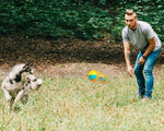 Load image into Gallery viewer, Man playing outdoors with a husky dog using an orange and blue dog training chew ball with draw rope tug toy