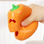 Load image into Gallery viewer, Hand squeezing an orange indestructible pumpkin-shaped chew toy designed for aggressive chewing dogs and puppies