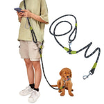 Load image into Gallery viewer, Person wearing hands-free dog leash with shoulder strap attached to a small golden retriever puppy sitting on the ground