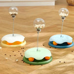 Load image into Gallery viewer, Three Interactive Cat Toy & Feeder Sets in yellow, green, and blue on a wooden floor, showcasing color options and treat-dispensing function.