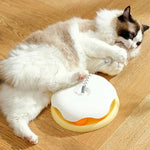 Load image into Gallery viewer, Cat lying on the floor while biting the spring of the Interactive Cat Toy & Feeder Set, showing its self-entertaining design.