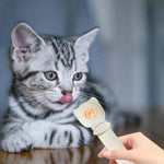 Load image into Gallery viewer, Kitten licking reusable cat strip feeder spoon with wet food dispenser held by hand indoors