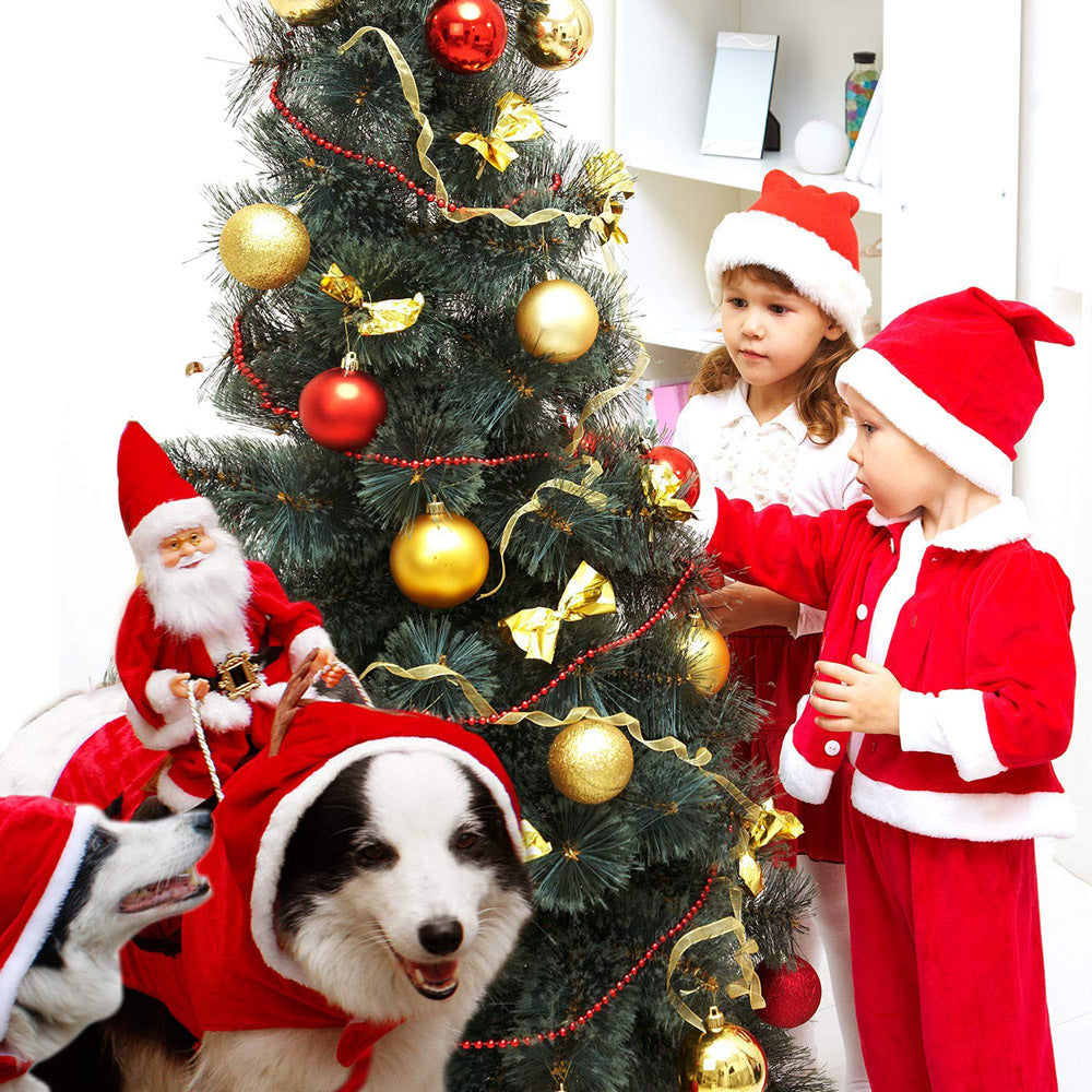 Two kids in Santa outfits decorate a Christmas tree while dogs wear Santa Claus reindeer costumes nearby