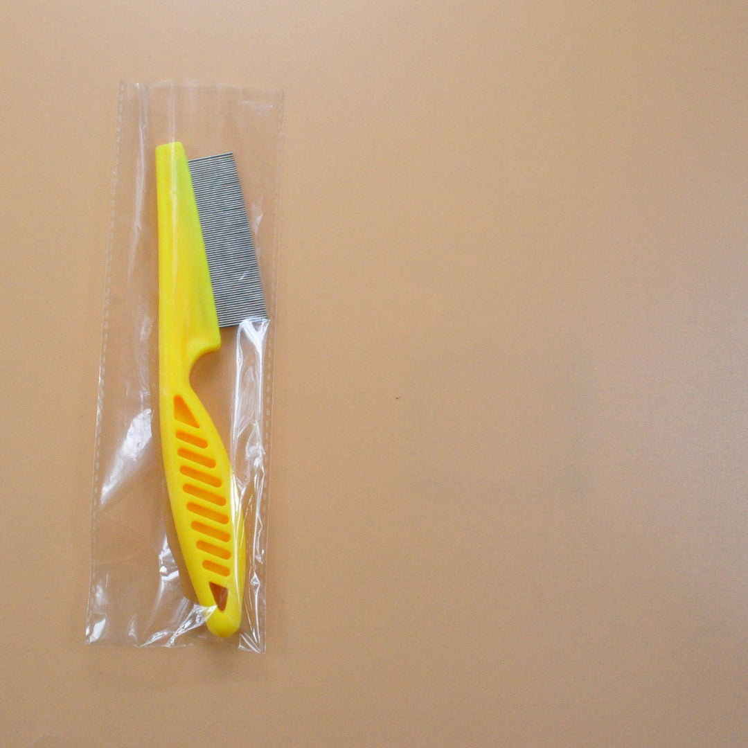 Yellow pet grooming flea comb in clear plastic wrap, fine tooth stainless steel comb for flea and tangle removal.