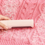 Load image into Gallery viewer, Pink 2-in-1 Pet Hair Remover Brush cleaning pet fur from a pink knitted sweater. Reusable and eco-friendly lint roller for home use.
