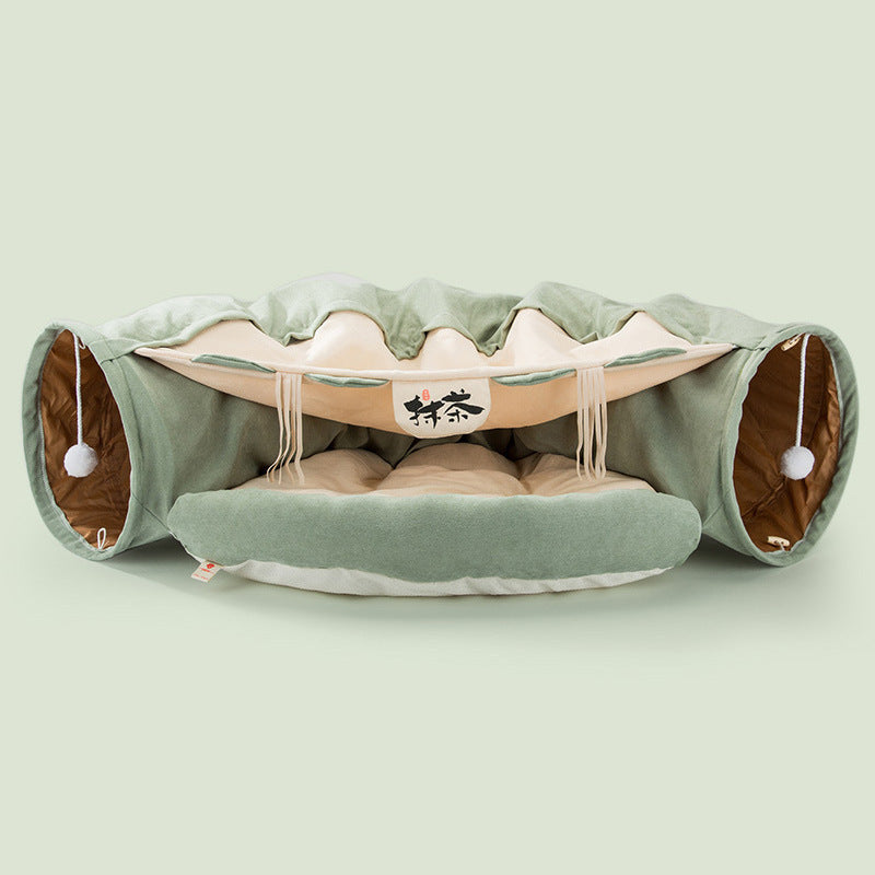 Green collapsible cat tunnel with soft cushioned interior and interactive hanging pom-pom toys for durable play and comfort