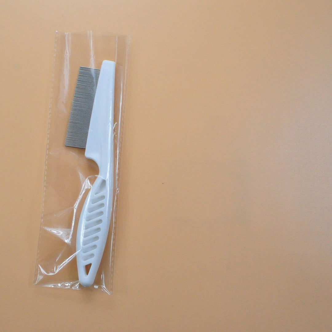White pet grooming flea comb in clear plastic wrap, fine tooth stainless steel comb for flea and tangle control.