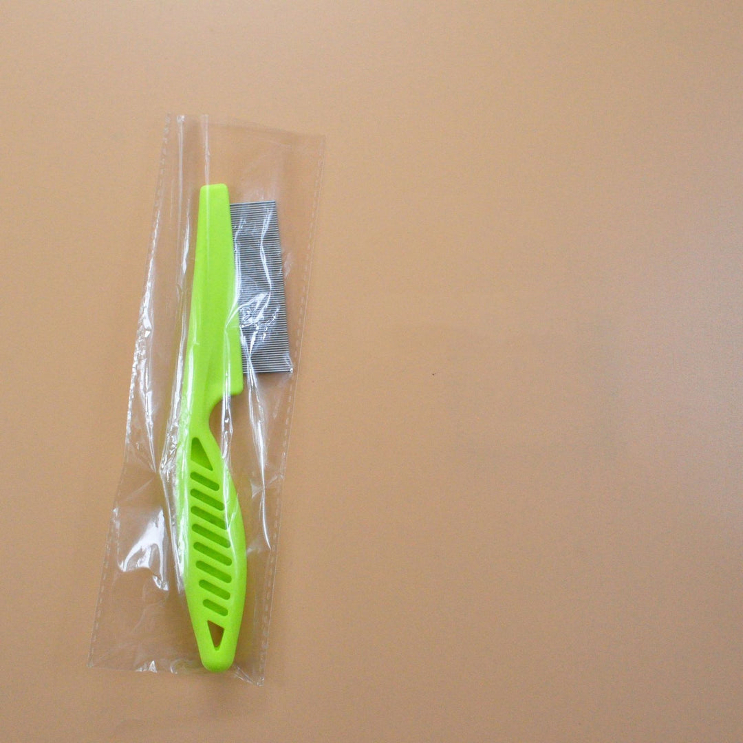 Green pet grooming flea comb in clear plastic wrap, fine tooth stainless steel comb for flea and tangle control.