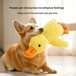 Load image into Gallery viewer, Dog gently biting a yellow squeaky duck plush toy designed as a calming chew pillow for dogs and puppies.
