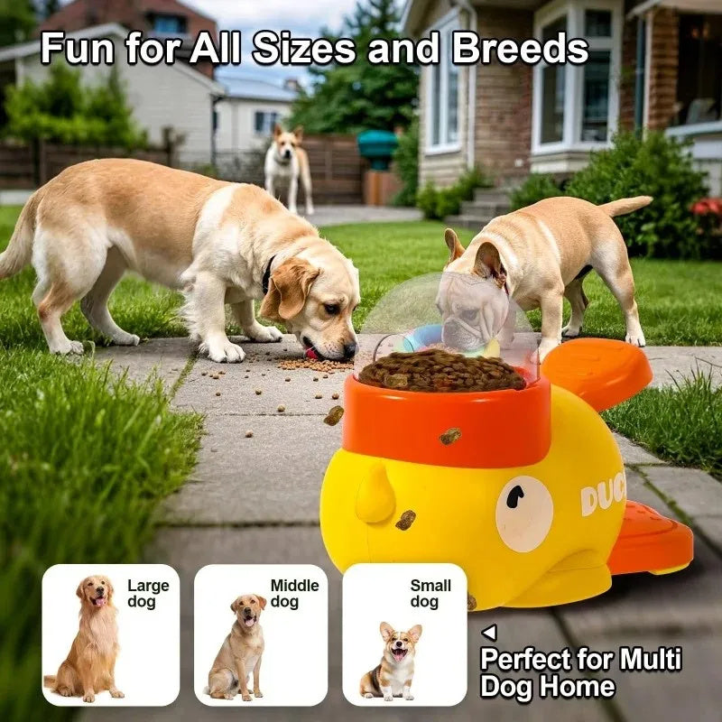 Yellow interactive dog puzzle feeder in duck design with two dogs playing outside on grass and pavement