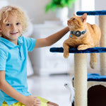 Load image into Gallery viewer, Child petting an orange cat wearing a reflective Airtag collar with bell on a blue cat tree indoors
