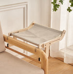 Load image into Gallery viewer, Light beige cat hanging bed attached to wooden sofa frame for cozy window or bedside perch space-saving spot
