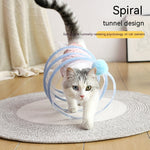 Load image into Gallery viewer, Cat playing inside a collapsible spiral tunnel toy with a blue pom-pom on a circular rug indoors
