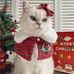 Load image into Gallery viewer, White cat wearing a red plaid Christmas cat shawl cloak with bell and matching hairpin in festive setting
