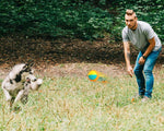 Load image into Gallery viewer, Man playing outdoors with a husky dog using an orange and blue dog training chew ball with draw rope tug toy
