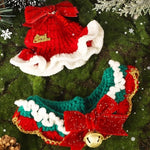 Load image into Gallery viewer, Knitted red and green Christmas pet scarves with white trim, red bows, and festive bell and decoration accents on a green background.
