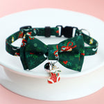 Load image into Gallery viewer, Adjustable green Christmas pet collar with festive bow tie and stocking charm for dogs and cats on white plate.
