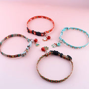 Four adjustable polyester Christmas pet collars with festive charms and bells on a pink background
