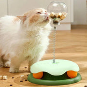 Interactive Cat Toy & Feeder Set with turntable ball and spring-mounted treat dispenser, engaging a fluffy cat during play and feeding.