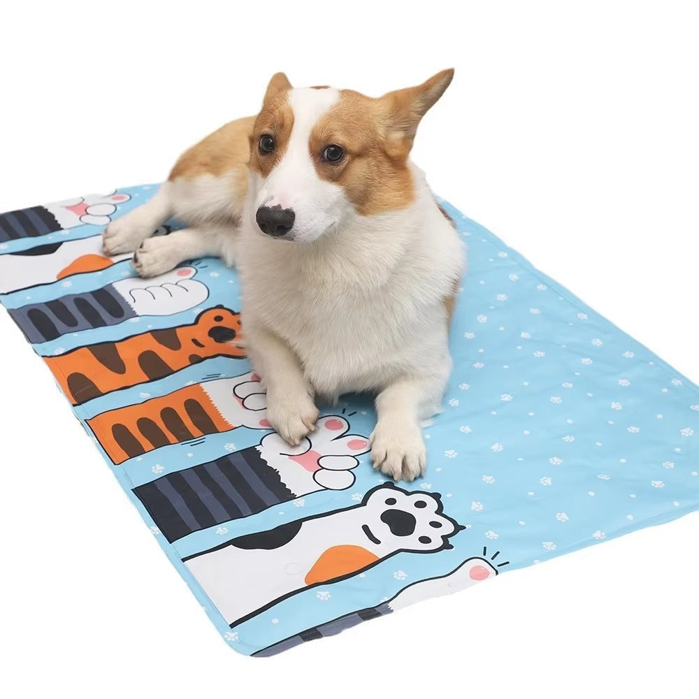 Corgi dog lying on a blue cooling dog mat with colorful animal paw prints, designed for summer comfort.
