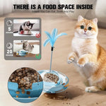 Load image into Gallery viewer, Orange and white cat playing with blue turntable feather cat toy with built-in food dispenser on wooden floor
