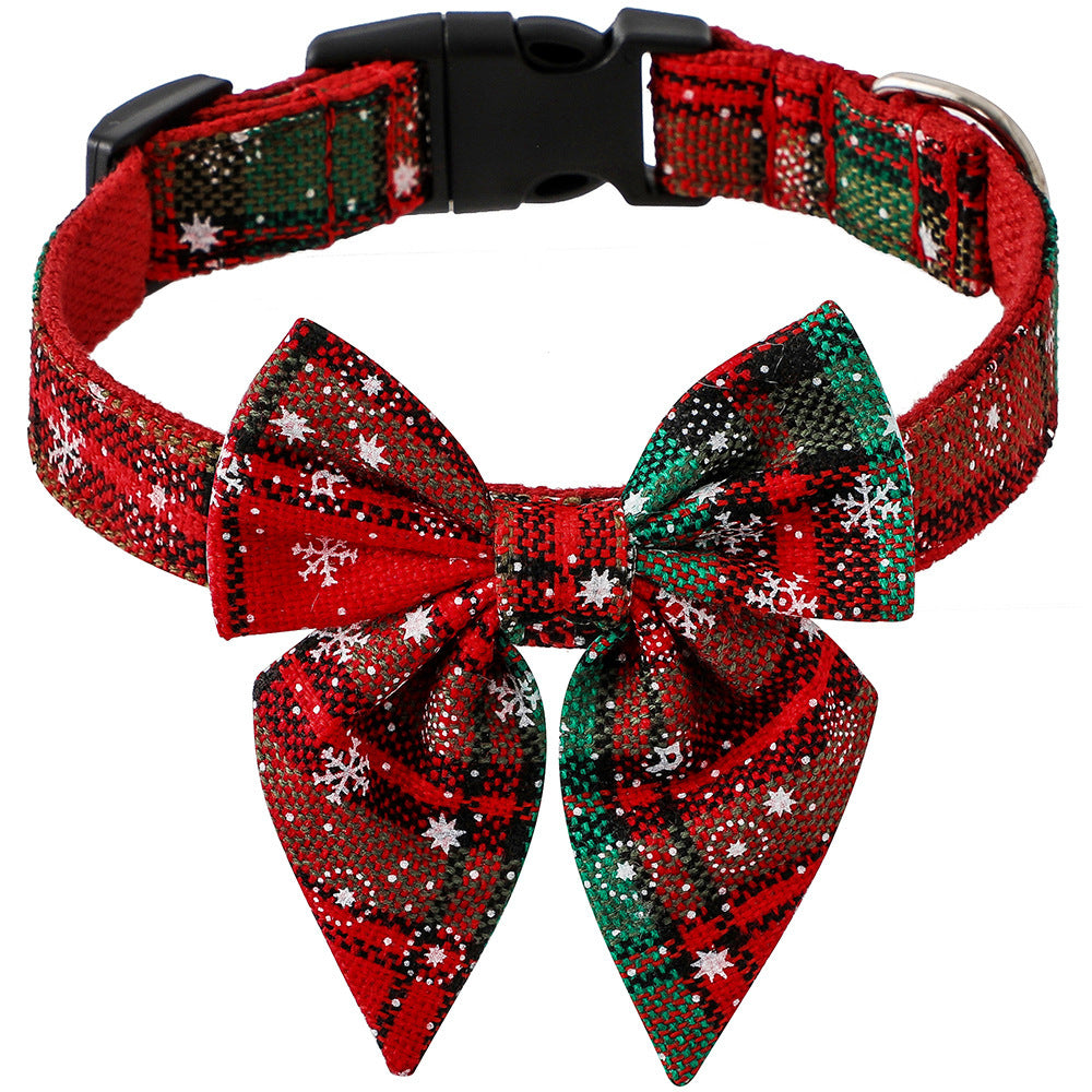 Adjustable Christmas dog collar with red and green plaid pattern and attached bow tie decorated with white snowflakes.