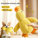 Load image into Gallery viewer, Hand holding yellow squeaky duck plush toy with dog biting same toy on cozy background
