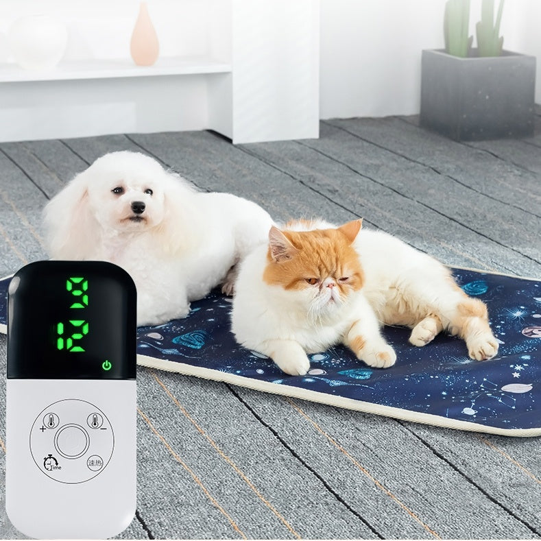 White dog and orange cat lying on an electric heating blanket with digital temperature control display visible nearby