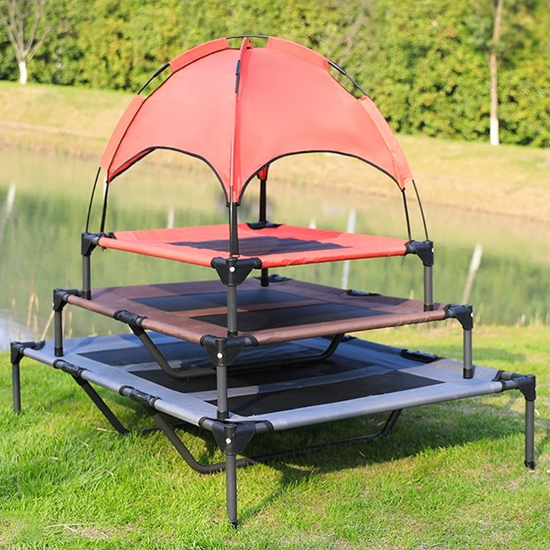 Stacked elevated pet beds with a breathable red canopy for shade and comfort outdoors on grass near water