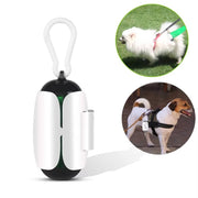 Portable white and black degradable dog poop bag dispenser with clip, shown attached to dog harnesses during walks.